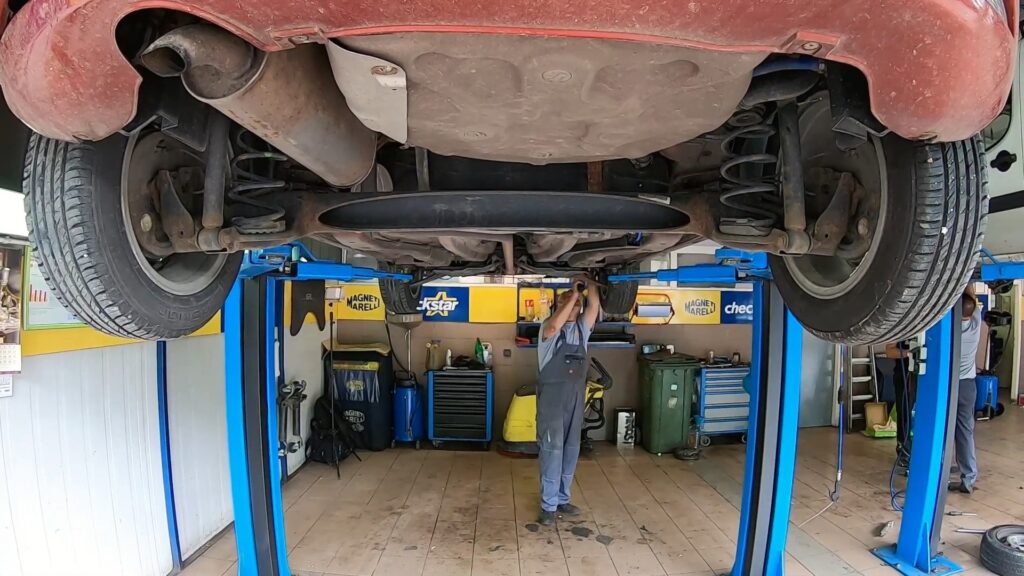 Automobil na dizalici tokom tehničkog pregleda u servisnoj radionici