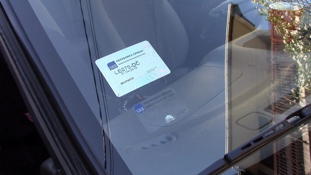 Registraciona nalepnica zalepljena na vetrobranskom staklu automobila u Srbiji