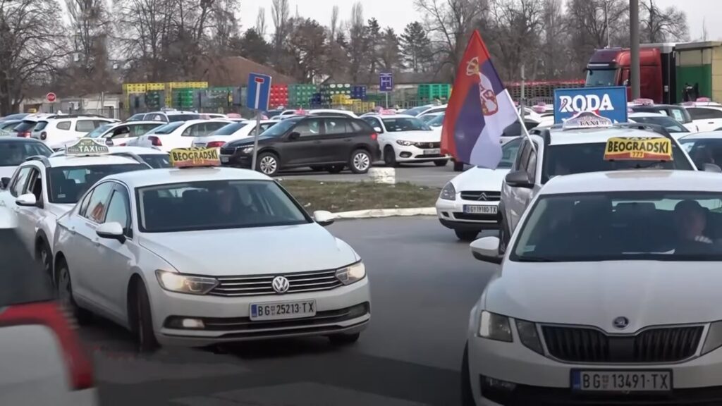 Taksi vozila u Beogradu sa TX tablicama i oznakama "Beogradski", u vožnji sa srpskom zastavom